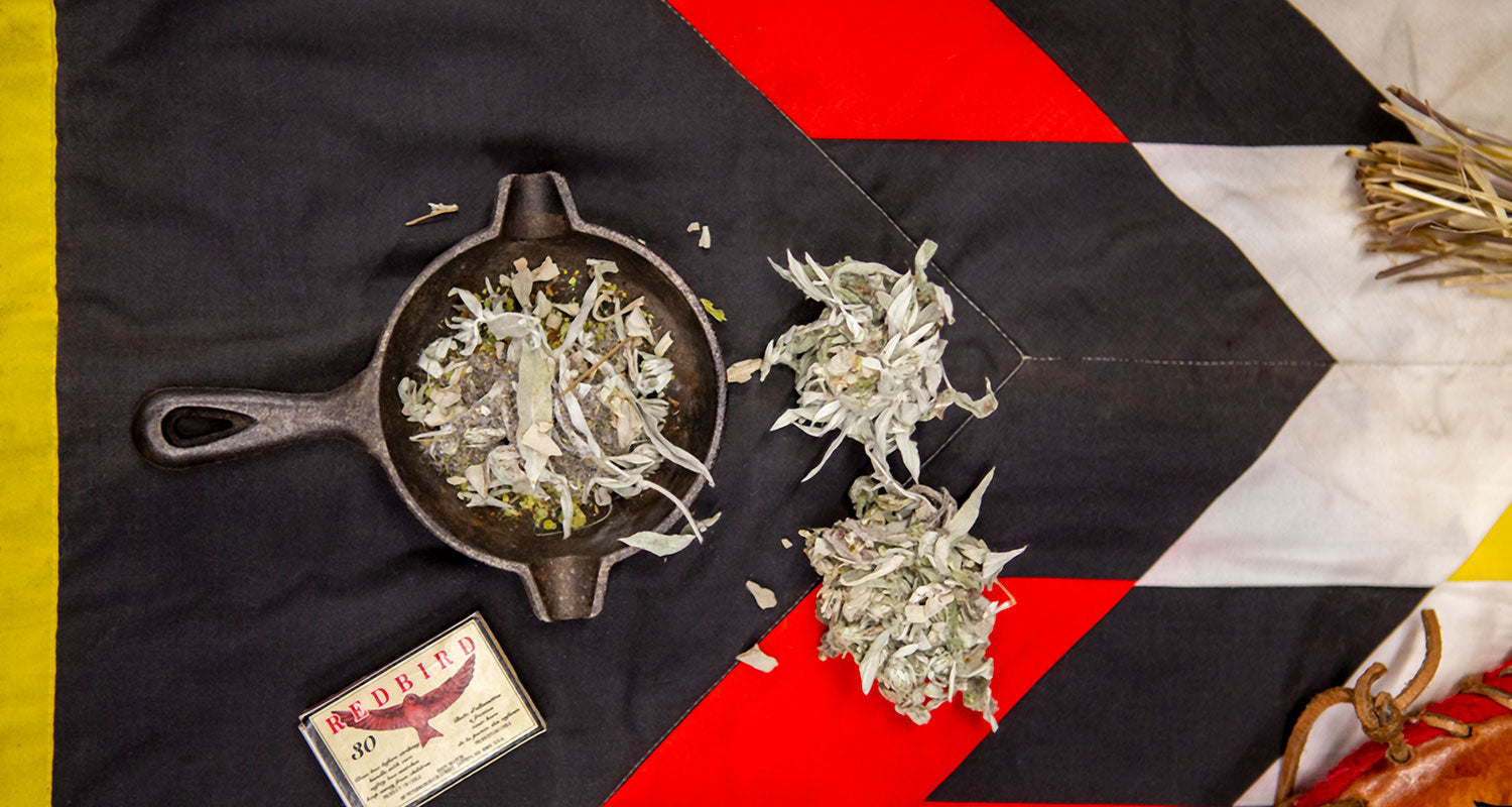 Traditional indigenous smudge ceremony with a motif blanket, cast iron skillet, dried sage and matchbox