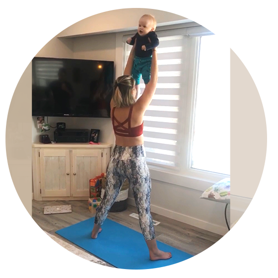 Woman in workout clothes lifting a toddler