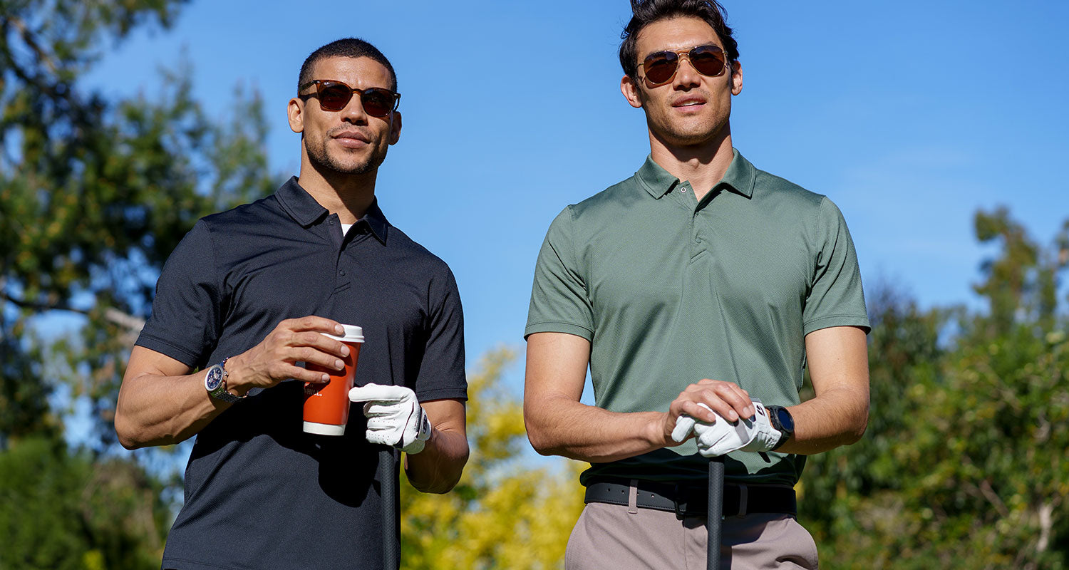 Two MPG male models on a golf course, wearing black and green golf shirts and sunglasses
